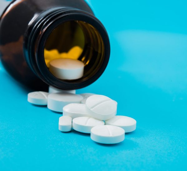 Medical pills spilling out of a toppled from pill bottle
